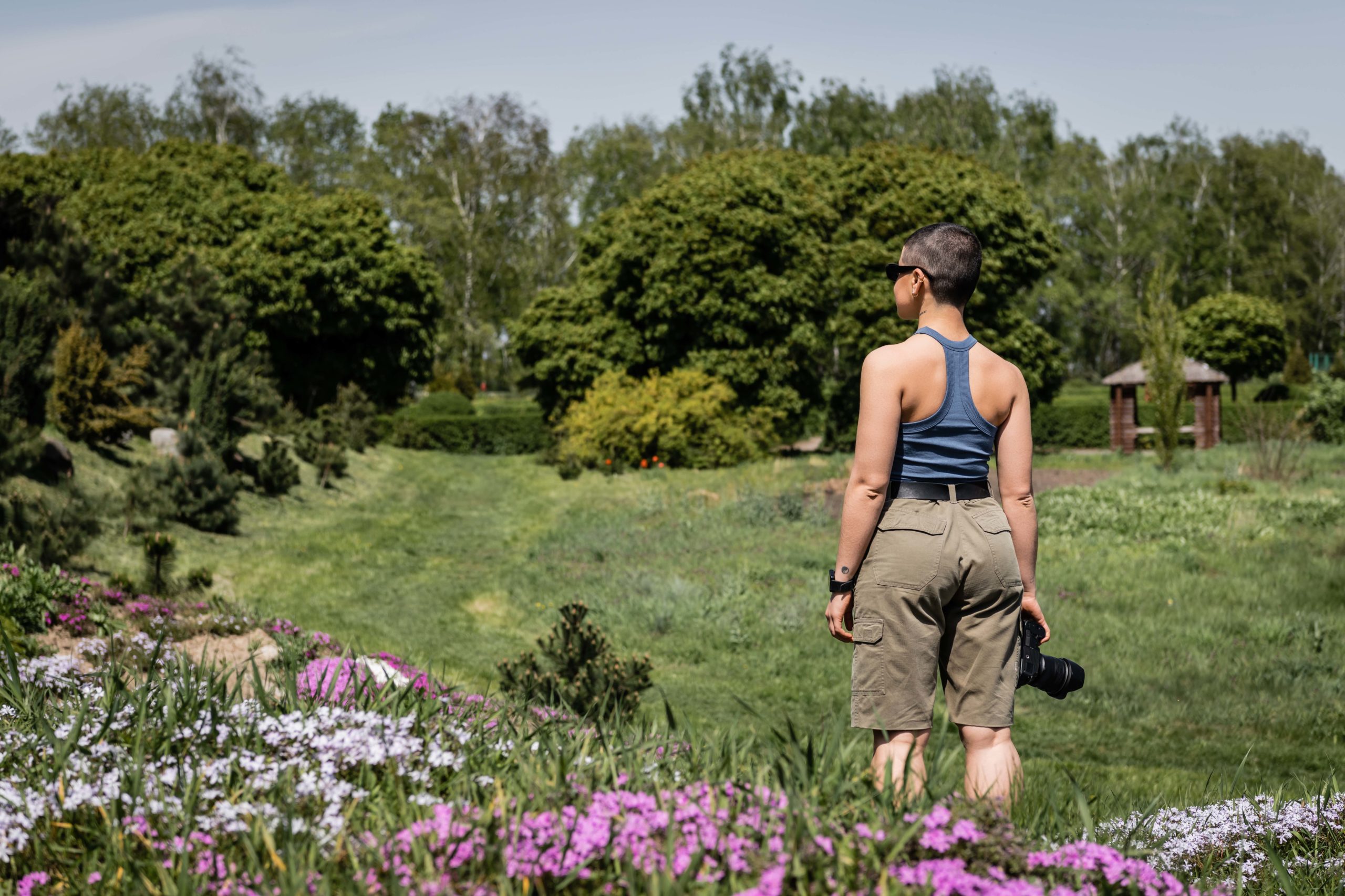 Side view of young short haired and tattooed female hiker in sun